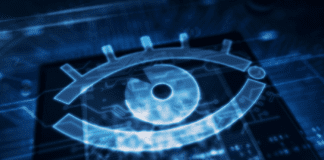 Cyber surveillance concept with spy eye hologram over CPU in background.
