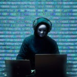 A masked hacker with binary numbers in background.