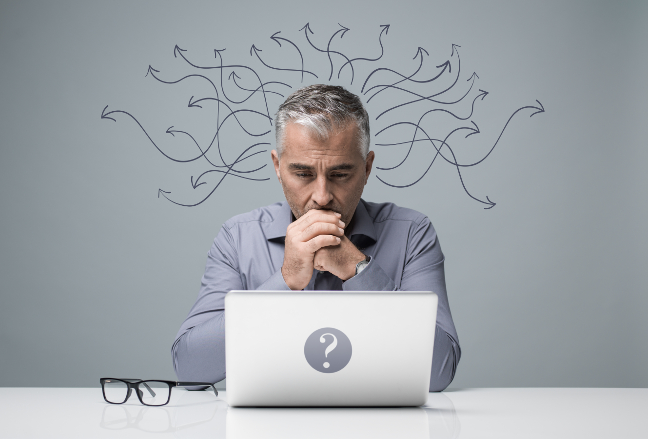 A man thinking while in front of his laptop.