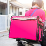 Motorbike delivery man wearing pink uniform and ready to send food.