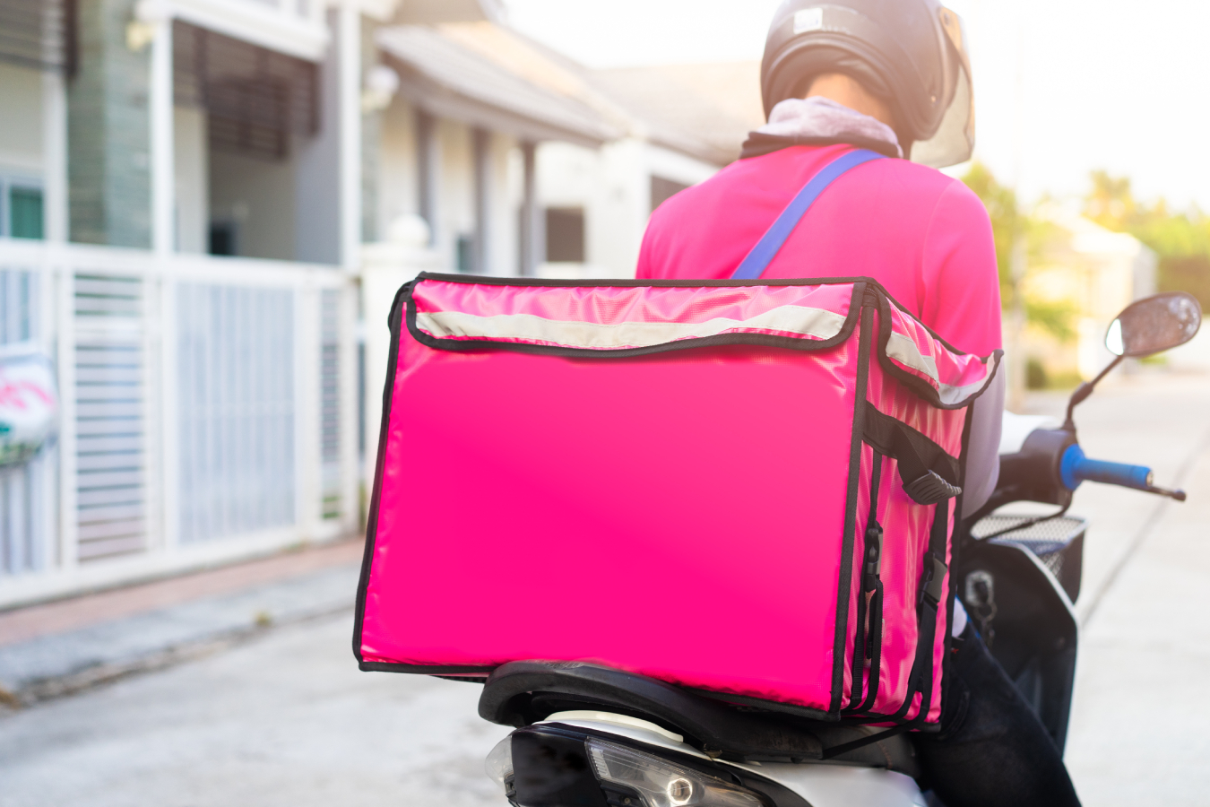 Motorbike delivery man wearing pink uniform and ready to send food.