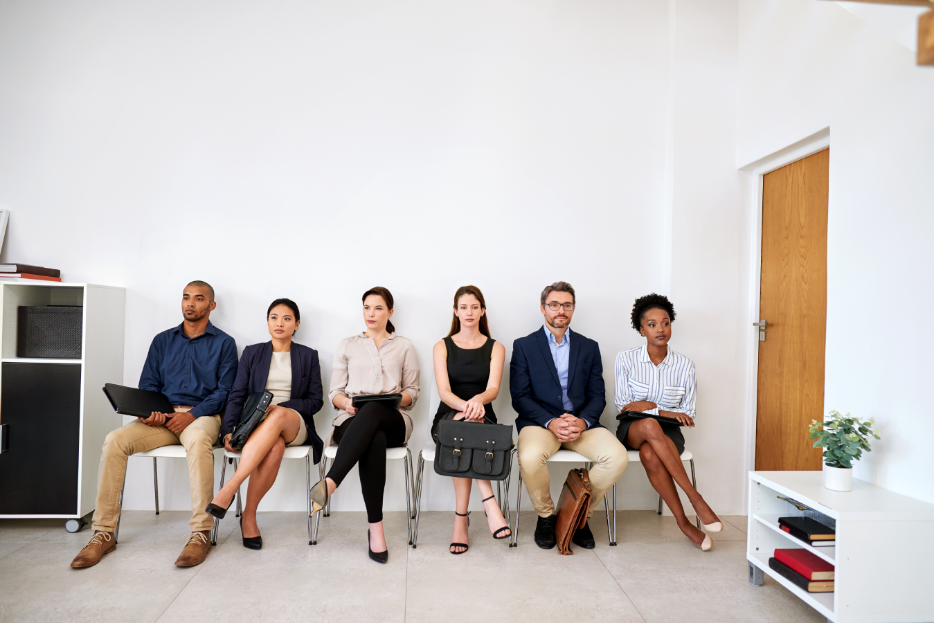 Shot of a group of businesspeople seated in line while waiting to be interviewed.