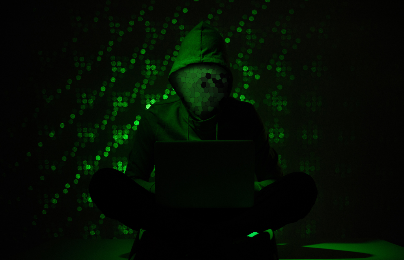 toned picture of hacker silhouette in hoodie using lapto